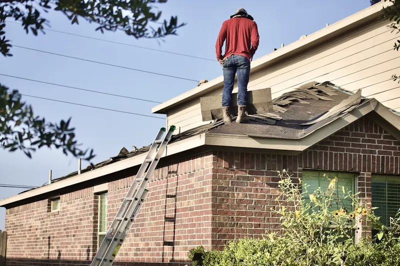 Professional roofer working on a residential roof in Lakes of The Meadow